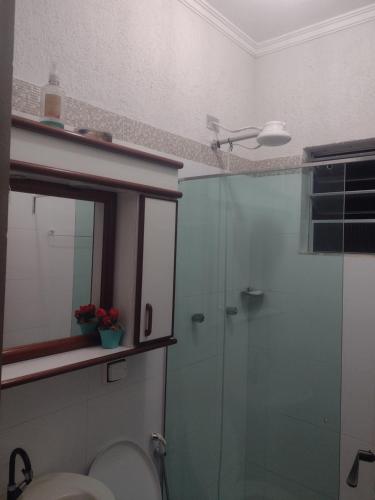 a bathroom with a toilet and a glass shower at Nossa Casa Ambiente Familiar in Águas de São Pedro