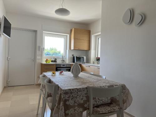 a kitchen with a table and chairs in a kitchen at Curri Case al Mare in Monopoli