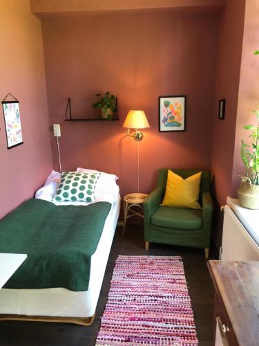 um quarto com uma cama e uma cadeira verde em FärgLabbets Bed and Breakfast em Sunne