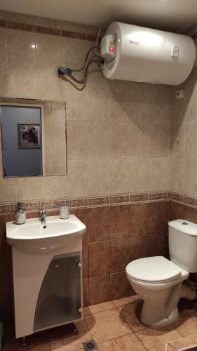 a bathroom with a toilet and a sink and a mirror at Студио Релакс, Ахелой in Aheloy