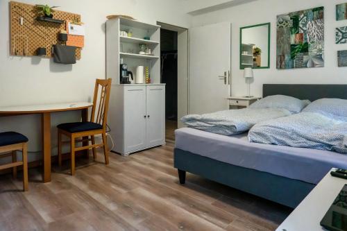 een slaapkamer met een bed, een bureau en een tafel bij Kleines Souterrain Apartment direkt am Park in Wiesbaden
