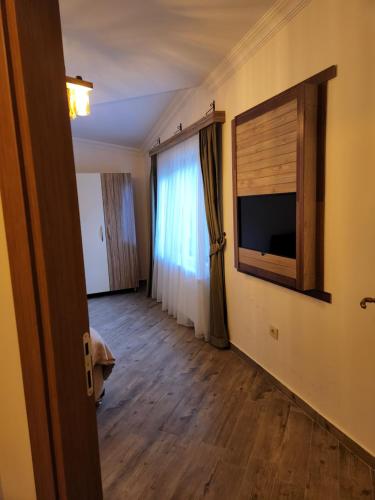 ein Wohnzimmer mit einem TV und einem Fenster in der Unterkunft Mersu A'la Konak Otel in Sapanca