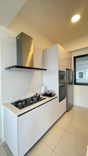 a white kitchen with a stove and a refrigerator at New 2BR Georgetown Warm and Lovely Homestay 10pax-无敌美景两房民宿 Beacon Executive Suite in George Town