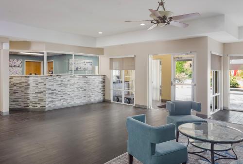 a living room with a ceiling fan and chairs at Sleep Inn & Suites in Foley