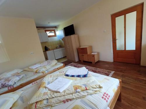 a room with three beds and a door at Sóhegy Panzió in Praid