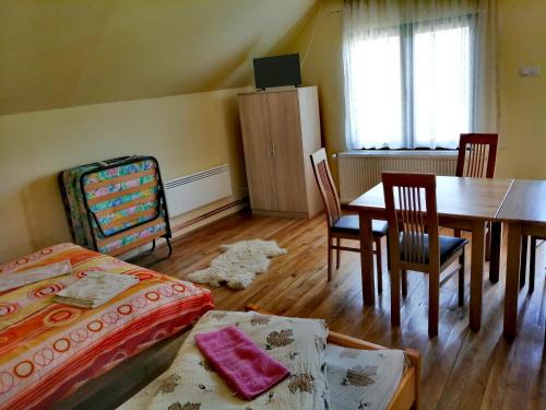 a bedroom with a bed and a table and chairs at Sóhegy Panzió in Praid