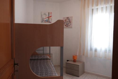 a bedroom with a bunk bed and a window at Casa DàCà in Marrùbiu