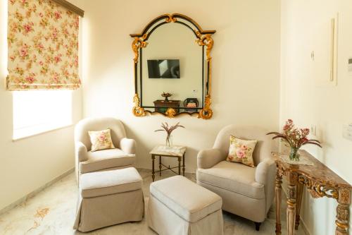 a living room with two chairs and a mirror at Solar Alvura Boutique Hotel in Moncarapacho