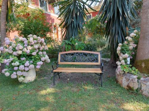 a wooden bench sitting next to a bunch of flowers at Niki Thalia Viros Apartment 2 in Kastanéa