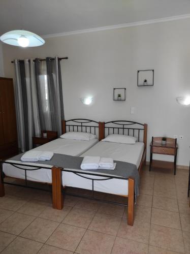two twin beds in a room with two tables at Vythos in Adamas