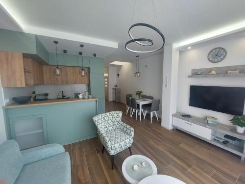 a living room with a kitchen and a living room with a tv at Apartment Sara with seaview in Budva