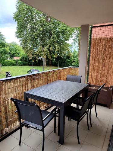a black table and chairs on a patio with a fence at T2 en centre ville avec place de parking privative in Le Mans