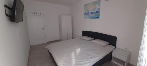 a small bedroom with a bed and a television at Apartment Rupena in Klimno