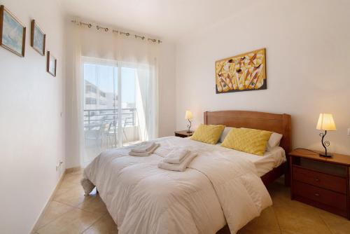 een slaapkamer met een bed met twee handdoeken erop bij Quarteira Beach iii in Quarteira