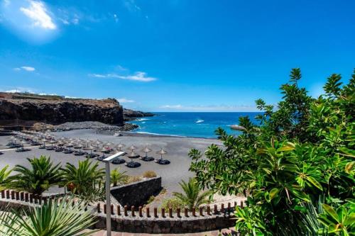 a view of a beach with chairs and the ocean at Chilly Apartment - Sunny rooftop terrace with ocean view in Callao Salvaje