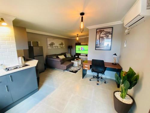 a living room with a couch and a table and a kitchen at 163 Bez Apartment 11 in Johannesburg