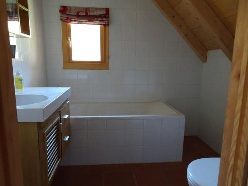 a bathroom with a bath tub and a sink at Chalet La Ruche in Saint-Sorlin-dʼArves