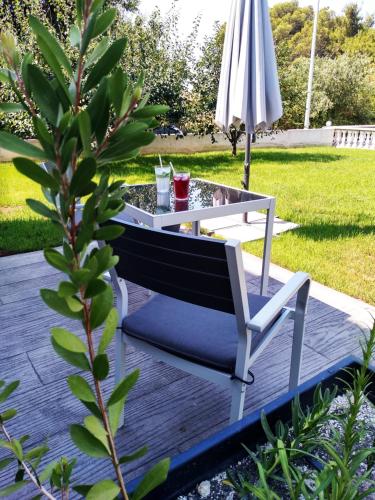 a table and a bench and an umbrella on a deck at House of Silence in Trogir
