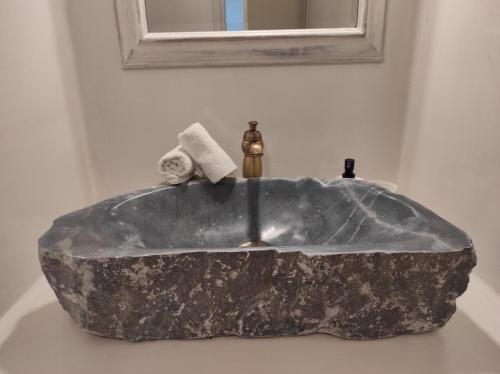 lavabo de roca en el baño con espejo en Traditional suites in Chora Kythnos #3, en Kithnos
