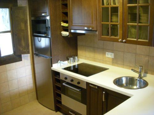 a kitchen with a sink and a stainless steel refrigerator at La Cuétara de Linares in Ribadesella