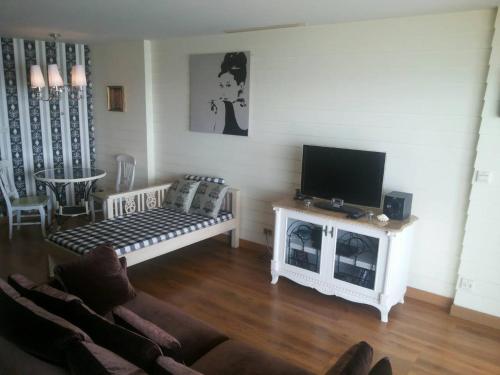 a living room with a couch and a flat screen tv at Sandy Beach E18 in Cha Am