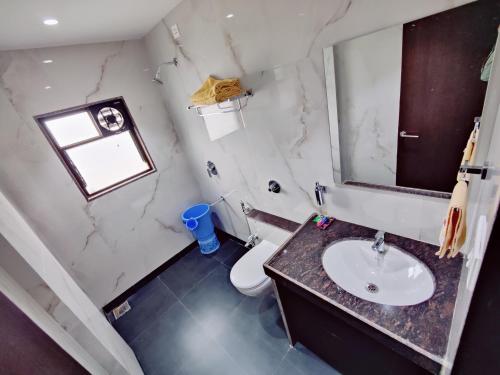 a bathroom with a sink and a toilet and a mirror at Shivanand Residency in Jejūri