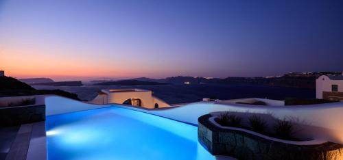 a swimming pool with blue lighting at dusk at Acro Blue Luxury Villas in Akrotiri