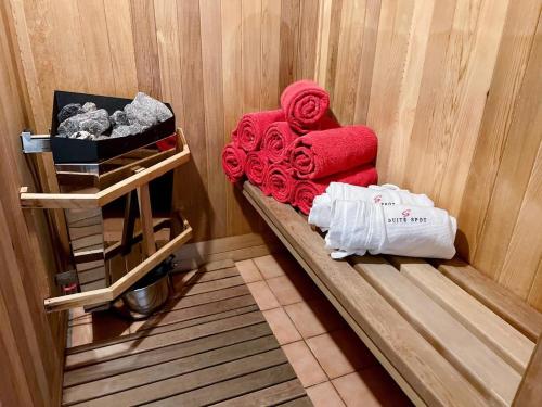 a bench in a room with red blankets and towels at 4 Storey Ski Inout Mountain Home In Tremblant in Mont-Tremblant