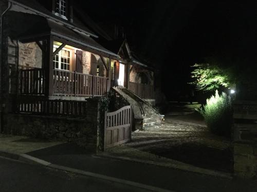 une maison la nuit avec une clôture devant elle dans l'établissement Ground floor stylish french holiday home, à Arnac-Pompadour