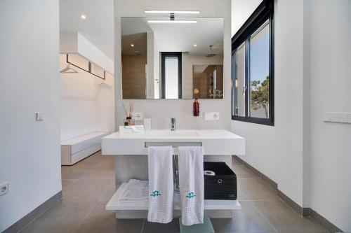 uma casa de banho com um lavatório e um espelho em Lola Sea Villa em Novo Sancti Petri