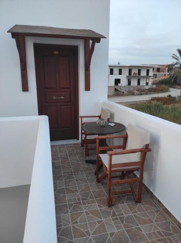 a patio with a table and chairs on a balcony at Vythos in Adamas