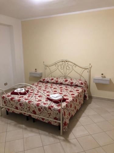 een slaapkamer met een bed met een rood en wit dekbed bij Residenza FILIPPO in Tropea