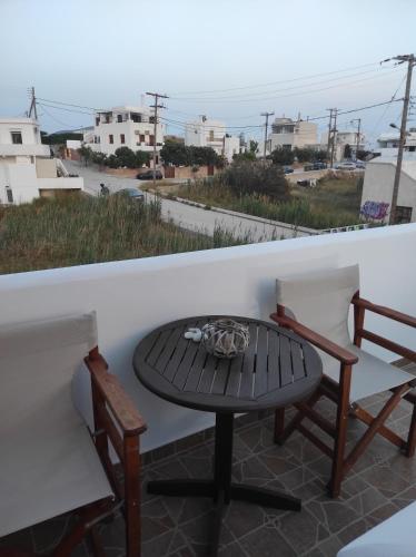 a table and chairs on a balcony with a view of the ocean at Vythos in Adamas