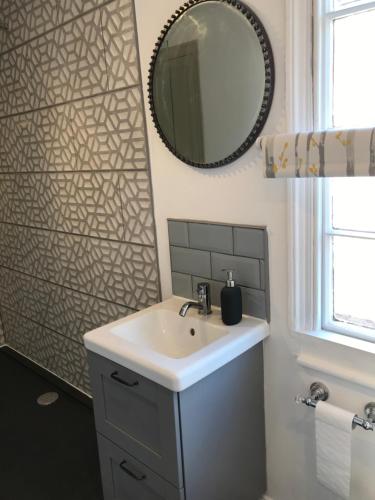 een badkamer met een wastafel en een spiegel bij Clerks Cottage in Upton upon Severn
