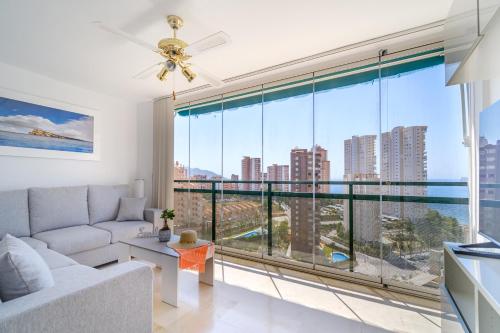 sala de estar con sofá y ventana grande en See the Sea Miramar apartment - 150m to the beach en Benidorm