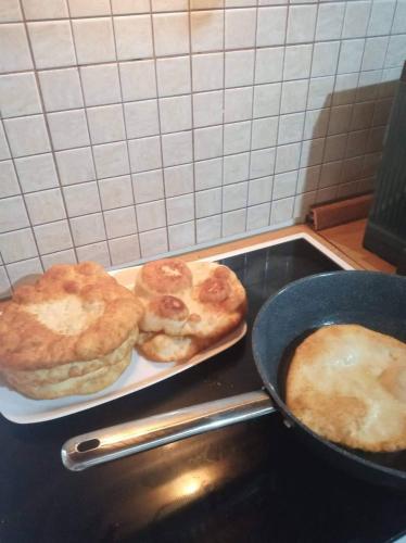 two pastries on a plate on a stove with a pan at Green Housee in Korçë
