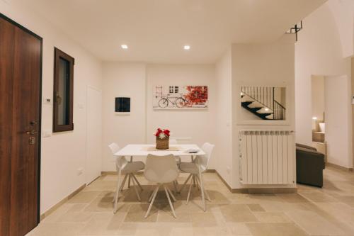 une salle à manger avec une table et des chaises blanches dans l'établissement Suite Matteotti, à Fasano