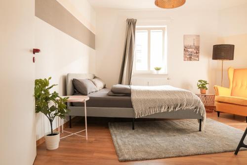 a bedroom with a bed and a chair at FullHouse - Halle - AB7 Apartments - City Center in Halle an der Saale