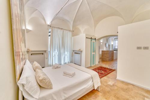ein Schlafzimmer mit einem weißen Bett in einem Zimmer in der Unterkunft Il Loft di Quintino in Parma