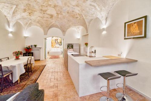 uma cozinha e sala de estar com mesa e cadeiras em Il Loft di Quintino em Parma