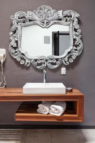 a bathroom with a sink and a mirror on a wall at El Mesón de Santa Rosa in Querétaro