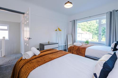 1 dormitorio con 2 camas y ventana en Woodyear Road, en Bromborough