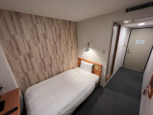 a small bedroom with a white bed in it at Kitami Daiichi Hotel - Vacation STAY 73134v in Kitami
