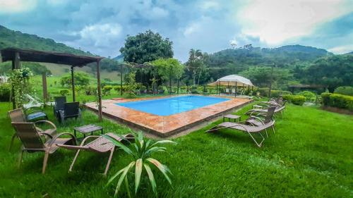a group of chairs sitting around a swimming pool at Hotel Fazenda Polyanna in Mariana