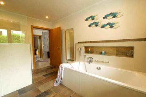 a large bathroom with a bath tub in a room at Ferienwohnung Maar-Idyll in Schalkenmehren