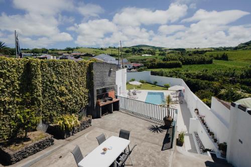 an external view of a villa with a patio and a swimming pool at Cantinho do Pensamento in Ribeira Grande