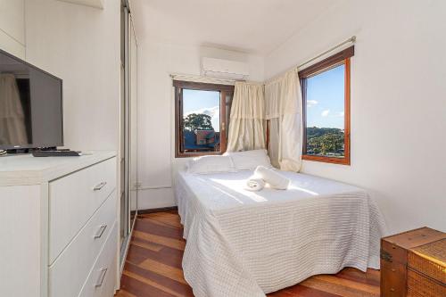 a bedroom with a bed with a towel on it at Apto com banheira de imersão - Stay House in Canela