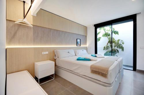 a bedroom with a white bed with a large window at Andrea Sea Villa in Novo Sancti Petri