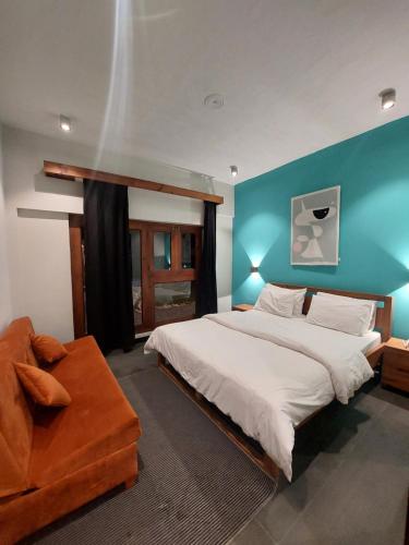 a bedroom with a large bed and a blue wall at Bela Resorts Naran in Naran