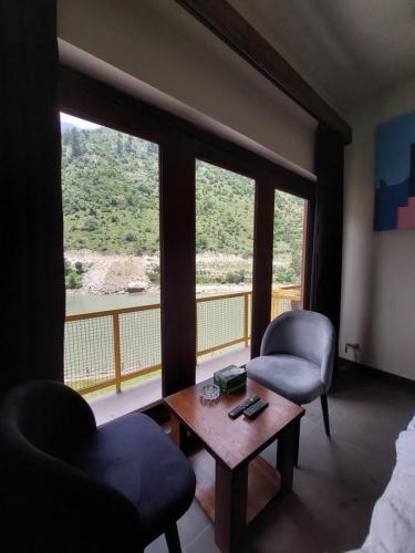 a room with two chairs and a table and a large window at Bela Resorts Naran in Nārān